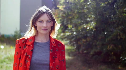 Model with red jacket posing and smiling in camera Stockbeeldmateriaal 59737595