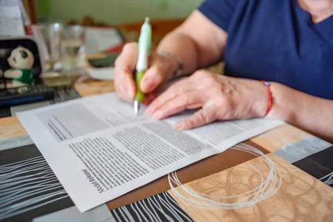 Model Release Form is Being Signed by Hands of an Elderly Woman at Home Stock Photos