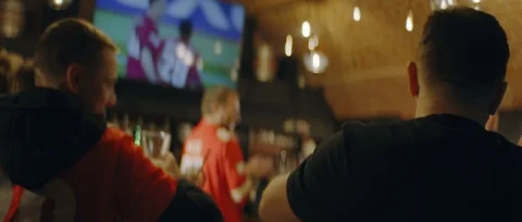 Model released, fans watching a game on a large TV in a sport pub Video stock 124559053