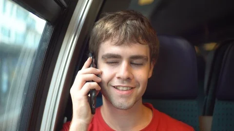Model Released - Young happy caucasian man talking on mobile phone inside train Stock Footage 93123588