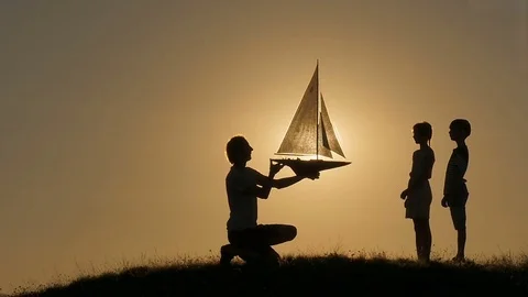 A model of a sailboat. A man is holding a ship model against the sky. The father Stock Footage 80319675