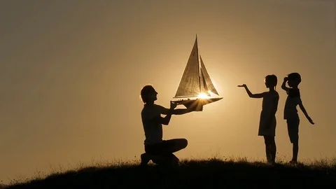 A model of a sailboat. A man is holding a ship model against the sky. The father Stock Footage 80319790