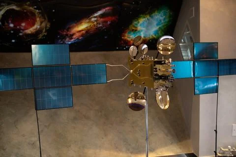 Model satellite with solar panels and reflective surfaces displayed indoors Stock-Fotos