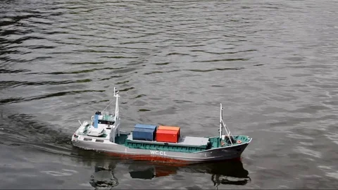 Model shipping container cargo boat turns in the water at model boat regatta Stock Footage 96077075