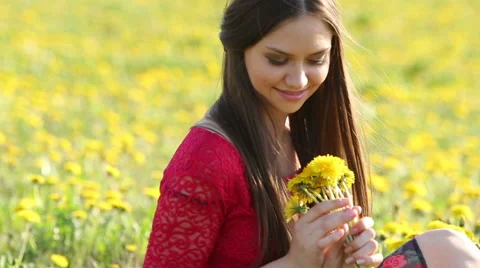 Model. Sitting among the blooming flowers of dandelion Stock Footage 63082445