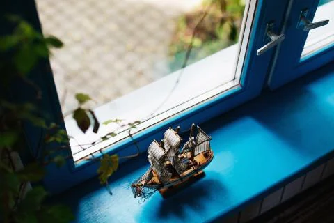 Model of a small sailing ship standing on a window sill Stock Photos