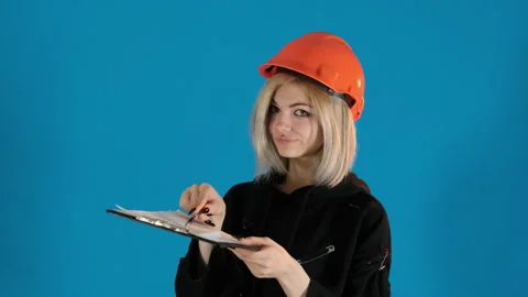 Model with smirk on face points pen at piece of paper Stock Footage 306501956