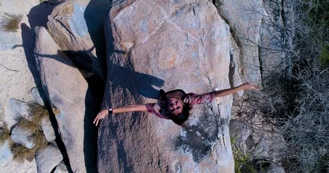 Model standing on big rock with arms wide spread looking in the camera, freedom Stock-Footage 104528529