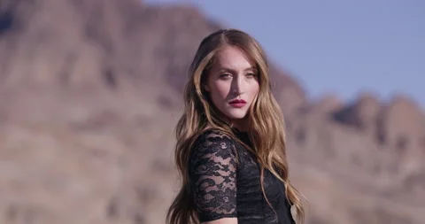 Model Standing in Desert Looking Into Camera Stock Footage 134082754