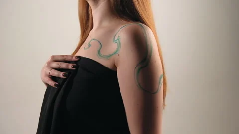 The model stands in the studio and shows a tattoo Stock Footage 184046804