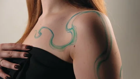 The model stands in the studio and shows a tattoo Stock Footage 184049319