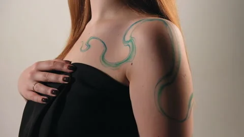 The model stands in the studio and shows a tattoo Stock Footage 184063292