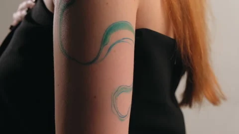 The model stands in the studio and shows a tattoo Stock Footage 184071305
