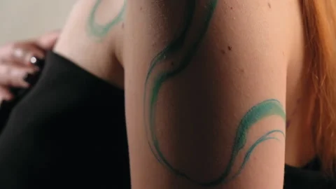 The model stands in the studio and shows a tattoo Stock Footage 184087128