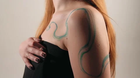 The model stands in the studio and shows a tattoo Stock Footage 184136971