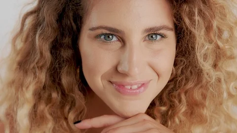 Model in studio with big curly blonde hair on white with natural makeup Stock Footage 96868712