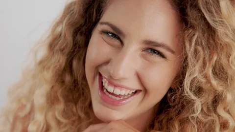 Model in studio with big curly blonde hair on white with natural makeup Stock Footage 97455390