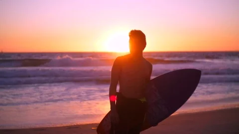 Model surfer with surf board posing in front of camera. Sunset vocation mood Stock Footage 82947183
