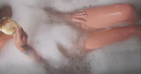 Model taking bath and touching herself naked while drinking a glass of Stock Footage 164208961