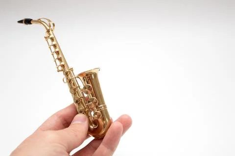 Model of toy bronze saxophone on hand Stock Photos