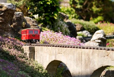 Model train on a bridge by rocks Stock Photos