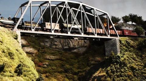 A model train drives over an elevated bridge. Stock Footage 63236972