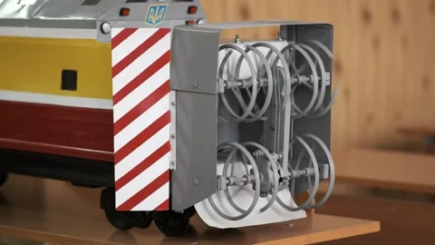 Model train with red and white striped barrier and gray snowplow on wooden .. Stock Footage 329178826