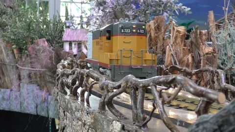 A model train runs on a high track in a holiday display 4K Stock Footage 119937867