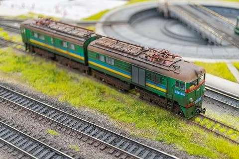 Model train set on realistic landscape backdrop, painted in vibrant green, .. Stock Photos