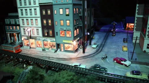 A model trolley drives through a model downtown cityscape at night. Stock Footage 63236618