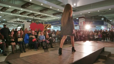 Model walking down runway, girl showcasing designs at catwalk, fashion show Stock Footage