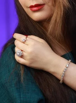 Model wearing two diamond-inspired rings and one gold bracelet Stock Photos