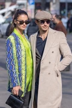 Model wears a fancy python coat and her partner a beige coat and a beret Stock Photos