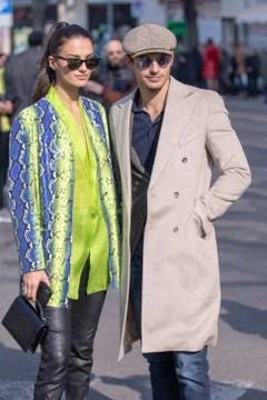 Model wears a fancy python coat and her partner a beige coat and a beret Stock Photos
