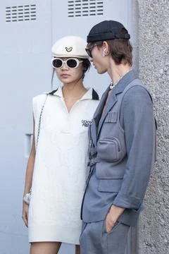 Model wears a gray jacket and a pearl necklace and a model a white dress Stock Photos