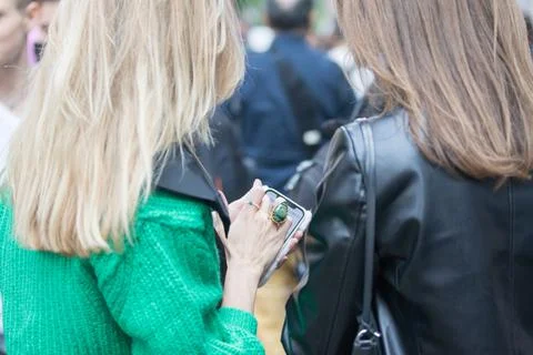 Model wears a green sweater and uses smartphone Stock Photos