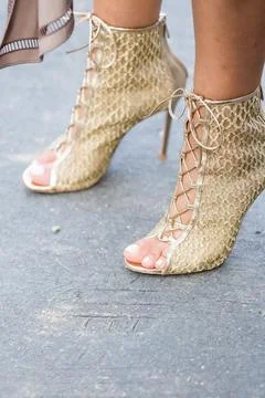 Model wears a pair of golden open heel shoes Stock Photos