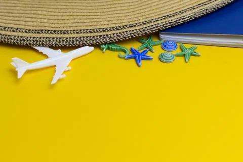Model of white airplane, beach hat, passport and starfishes on a yellow backg Stock Photos