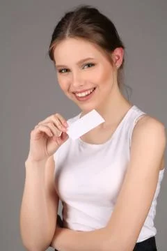 Model in white singlet posing with slip of paper. Close up. Gray background Stock Photos