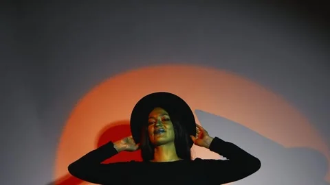 A model in a witchs hat is captured in a dramatic, low-light setting Stock Footage 319826080