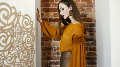 Model work, girl changes her poses in fashionable clothes stands near wall in Stock Footage 93542136