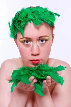 Modell mit bunten Make-up hält grünen Federn Modell mit bunten Make-up häl Stock Photos
