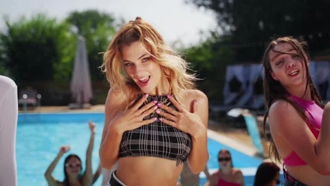 Models dance, twerk, sing and relax with alcohol cocktails at swimming pool Stock Footage 276088606