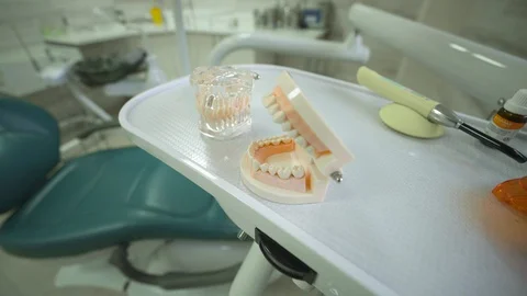 Models of dental jaws are on table in modern dentist's office. Dentistry and Video stock 129686262