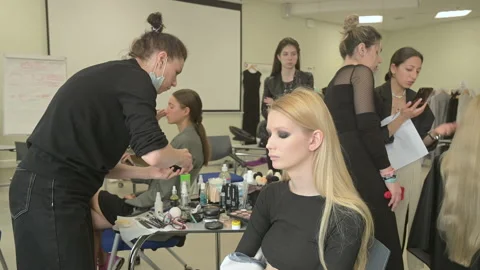 Models do a make-up and hairstyle before start the SEMILETOVA fashion show. Stock Footage 140058541