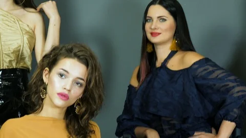 Models with expressive makeup in luxurious clothes pose on background wall Stock Footage 93542653