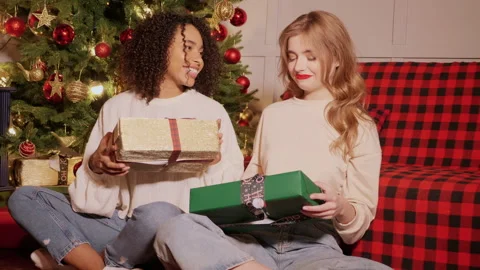 Models give each other gift near decorated Christmas tree at New Year eve Stock Footage 146132392