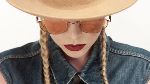 Models in hat with two braids and glassess, looks like a cowboy girl Stock Footage 96884310