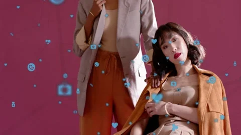 Models posing on pink backdrop, blue icons drifting, standing model placing Stock Footage 333494269