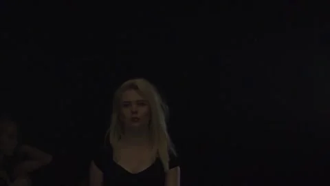 Models show clothes walking one by one into the center of the room. Black Stock Footage 94322336